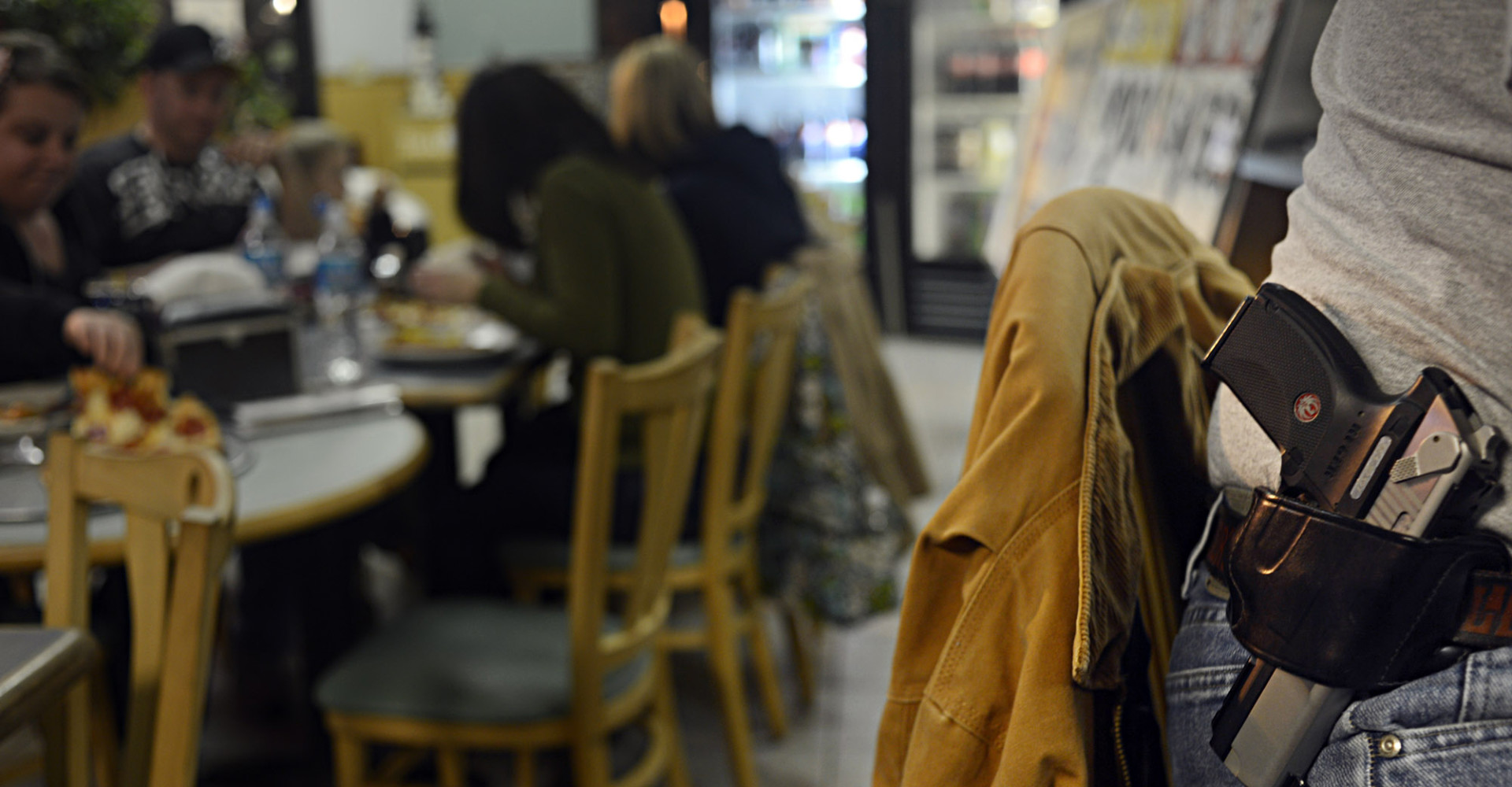 Kenneth Kormanis, right, had dinner with his wife and daughter at All Around Pizza in Virginia Beach, Va., on Monday, Feb. 18, 2013,  where anyone who carries a gun or brings a concealed handgun permit is offered at 15 percent discount.  (AP Photo/The Virginian-Pilot, Amanda Lucier) MAGS OUT